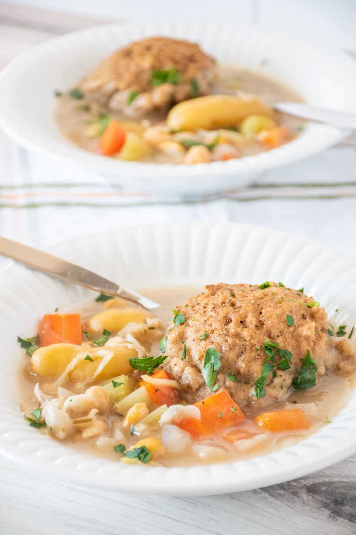 Bowl of vegetable stew with a dumpling. Another bowl visible in the background.