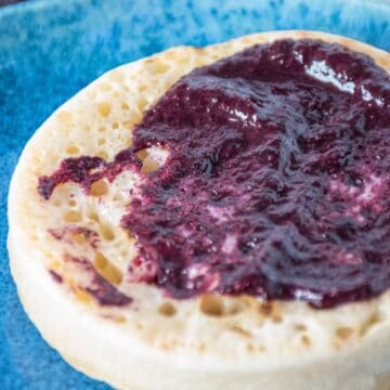 Close up of blueberry chia jam smeared on a toasted crumpet.