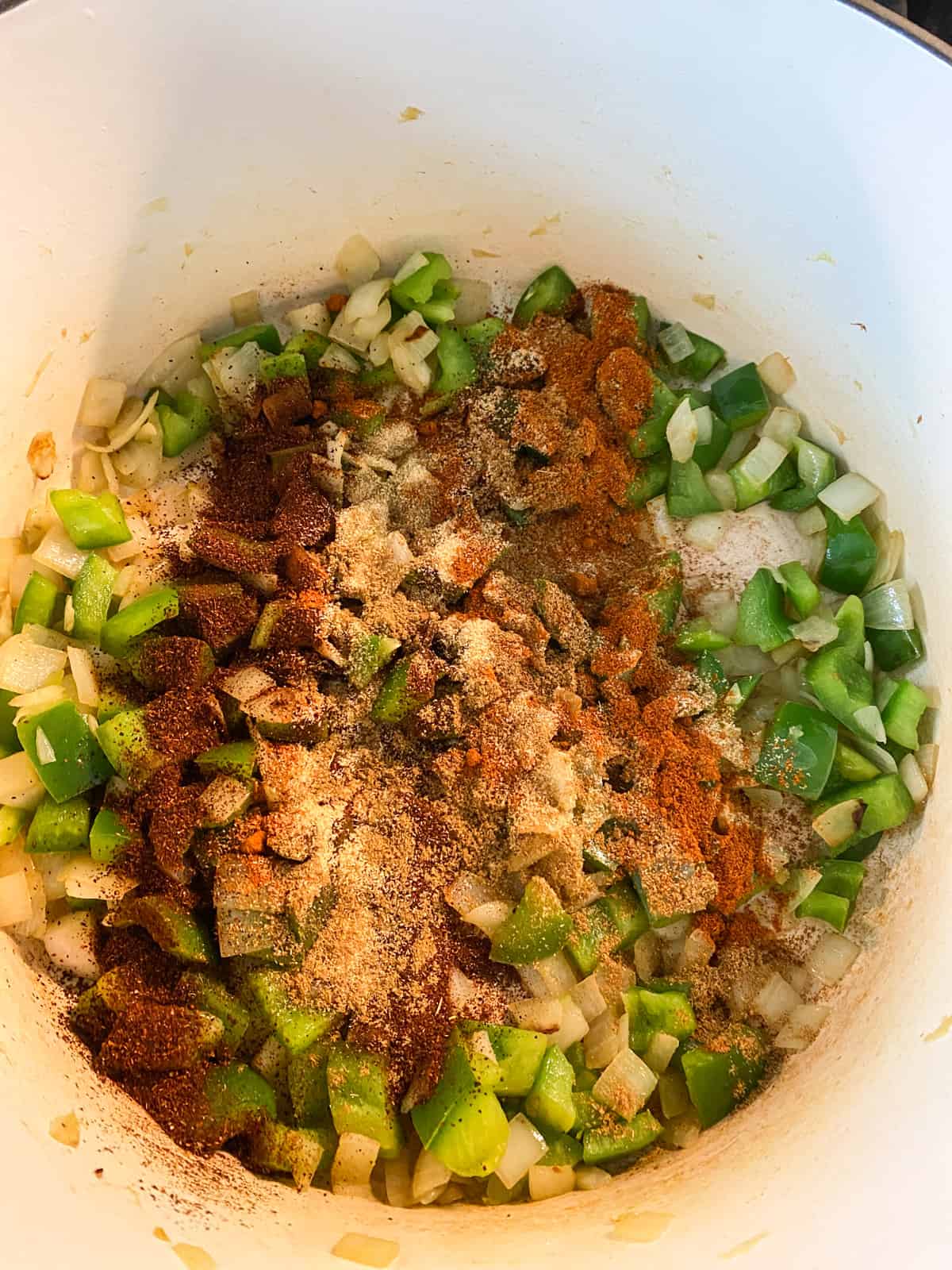 Spices added to pot of sauteed peppers and onions.