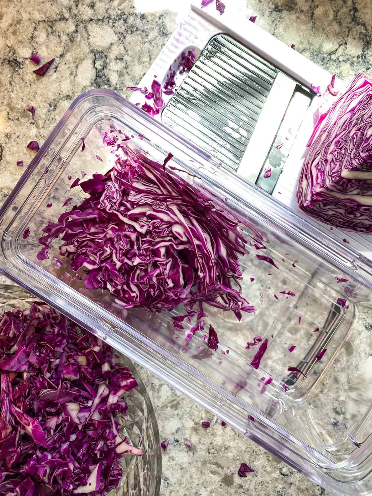 Shredded red cabbage in a vegetable shredder.