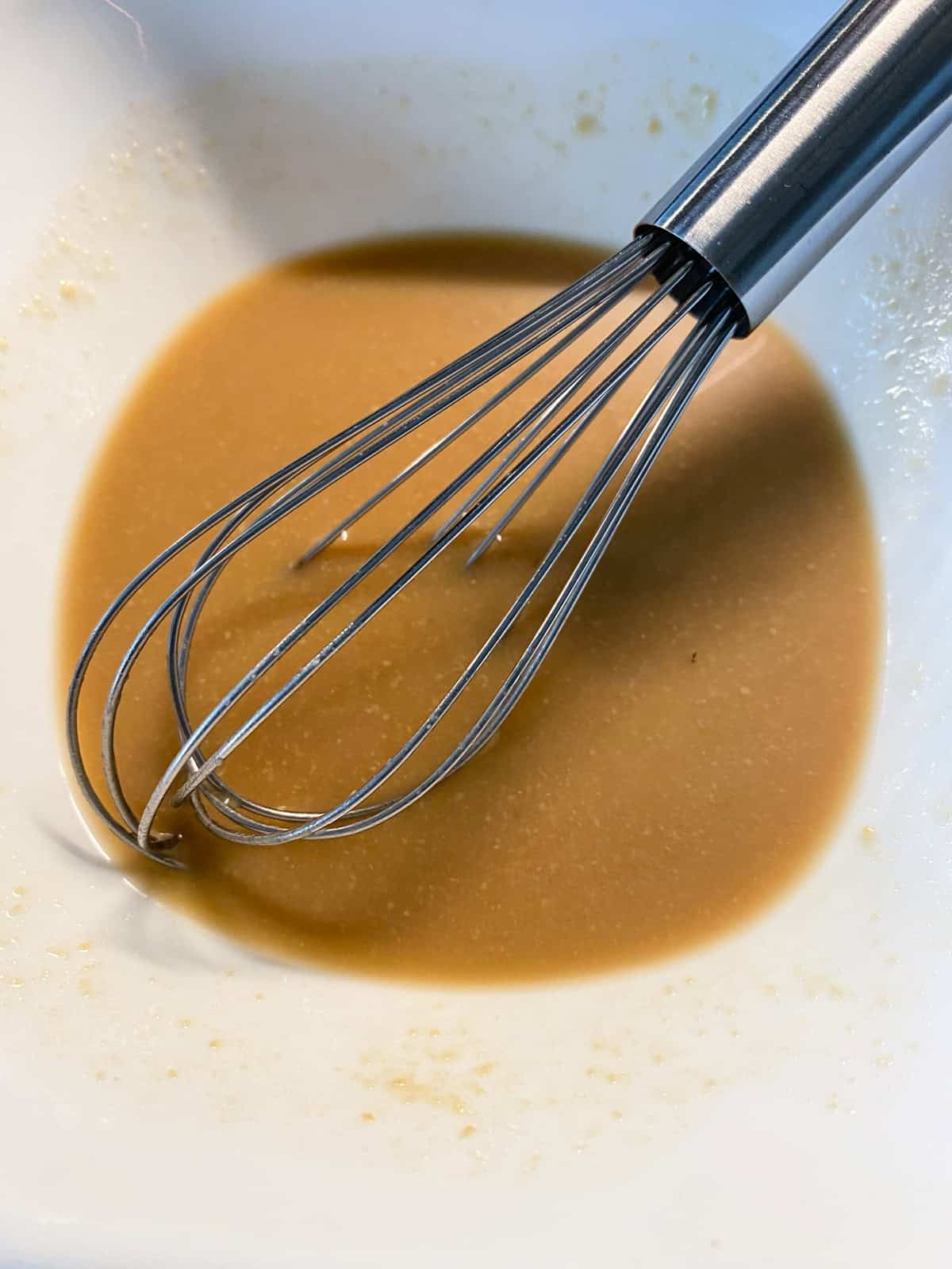 Miso paste mixed with some vegetable broth in a small bowl.