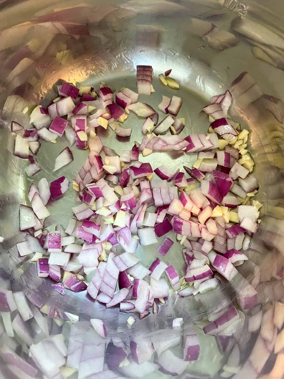 Onions and garlic sautéing in pressure cooker pot.