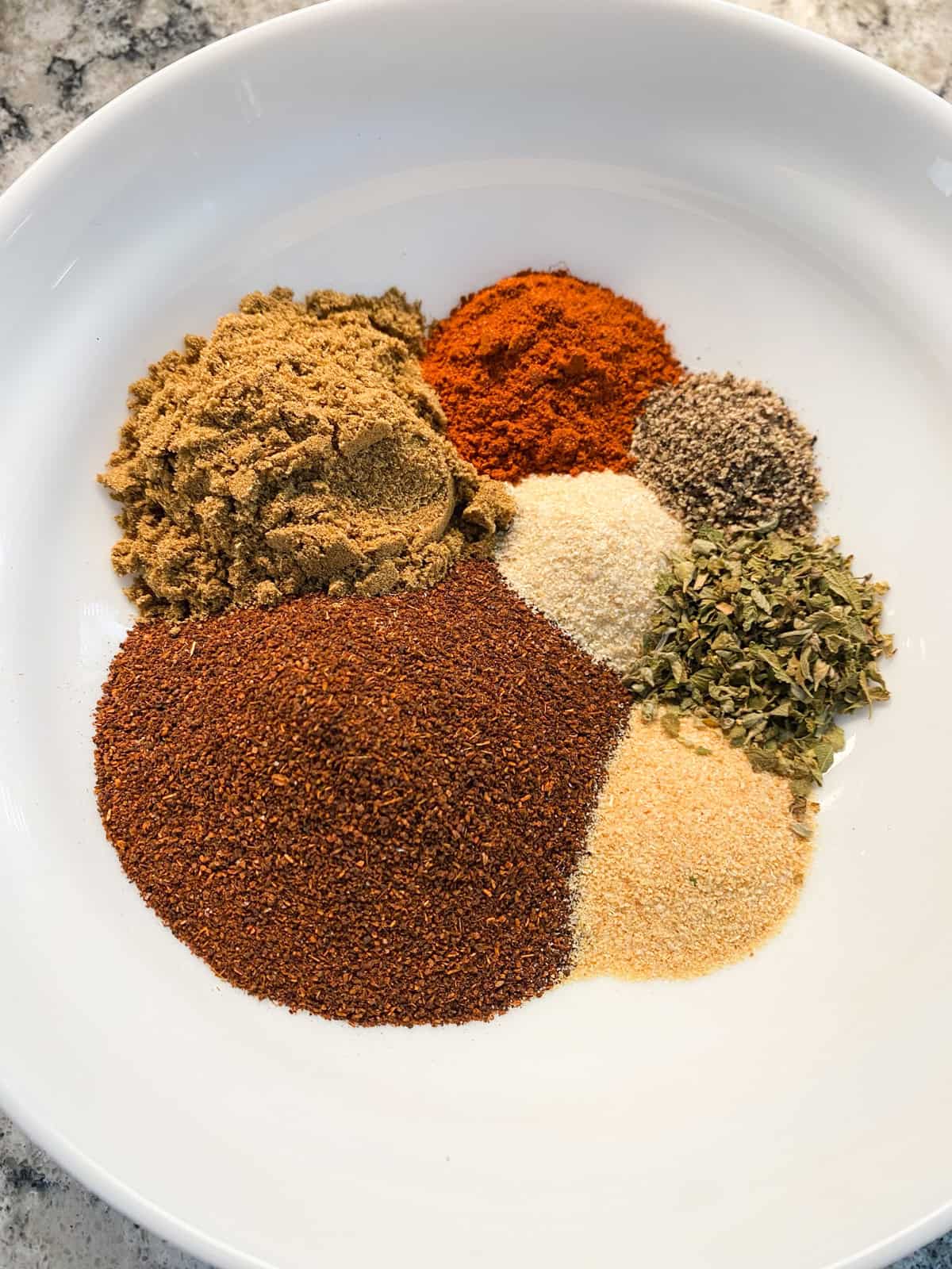 All the ingredients for salt free taco seasoning, measured into a bowl.