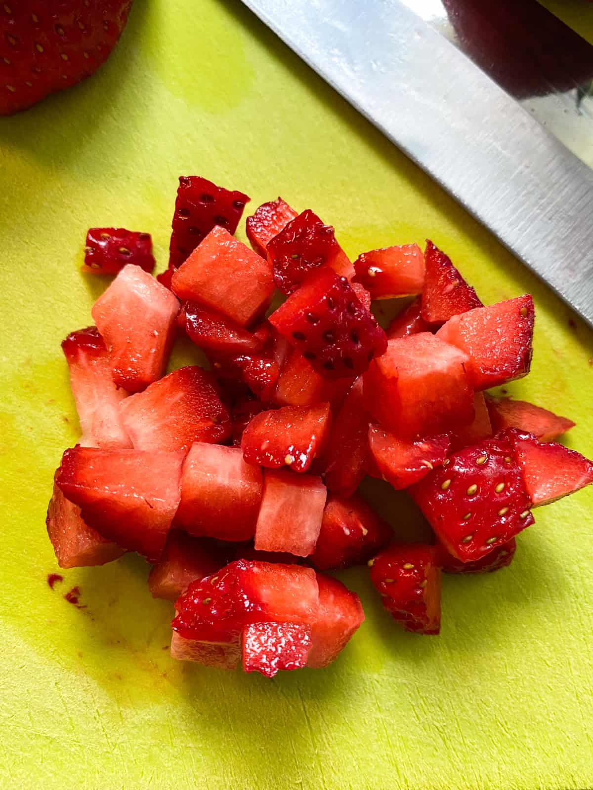 Minced strawberries on a cutting board.