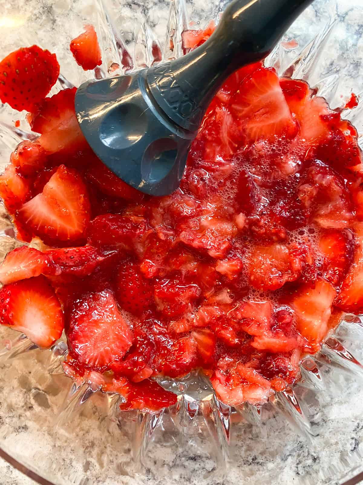 Mashed strawberries in a bowl.