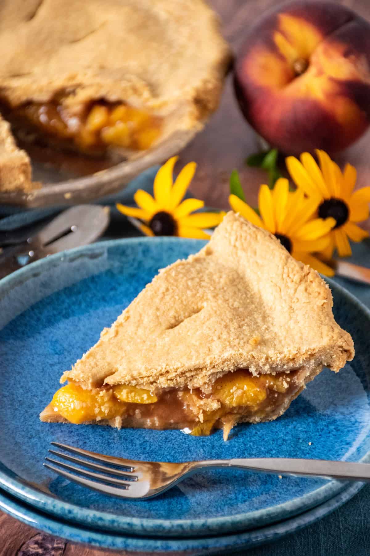 Slice of peach pie on a dessert plate.