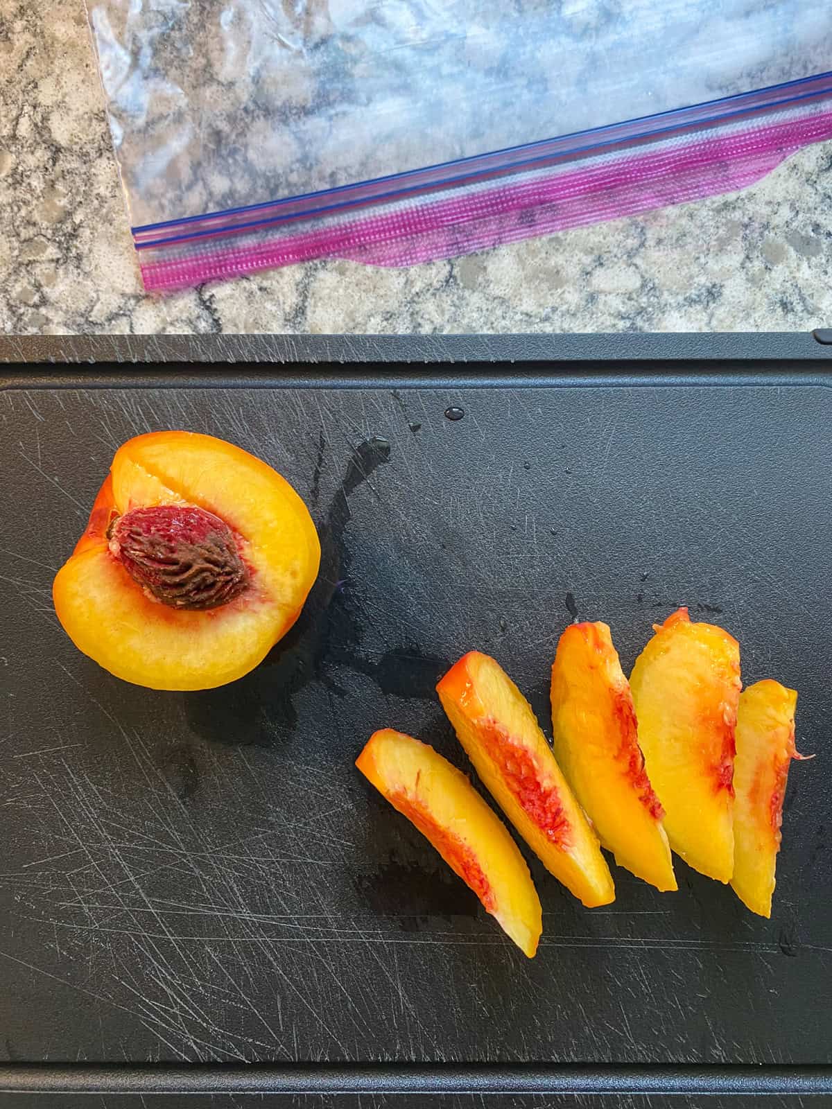A peach half, and slices on a cutting board.