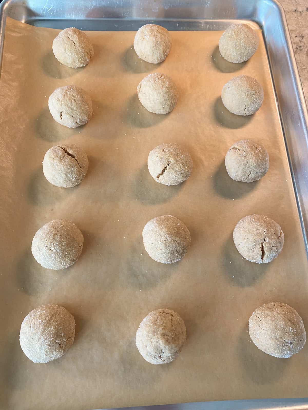 Baked cookies, on a tray, before adding chocolate kisses.