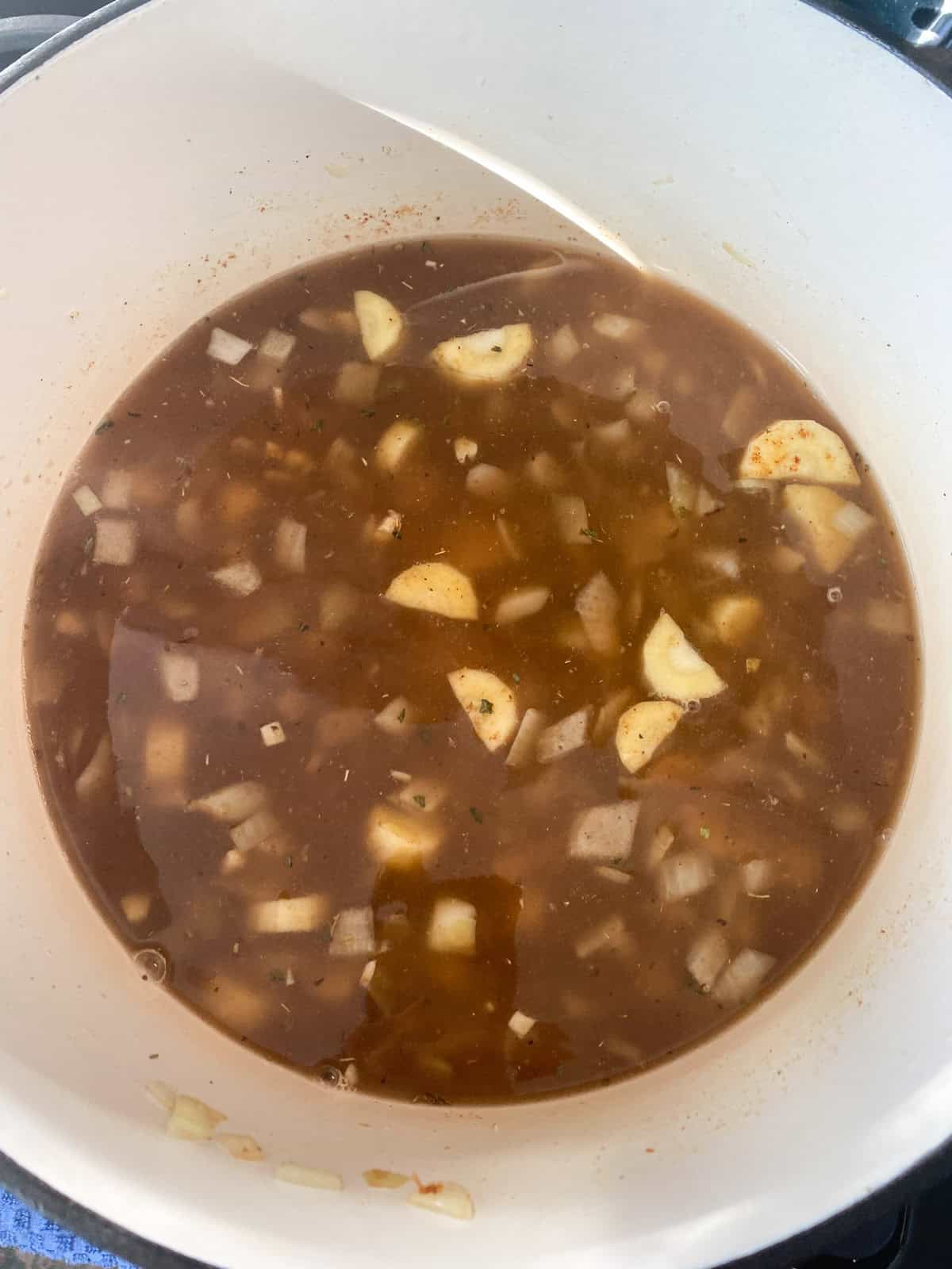 Vegetable stock added to the sauteed vegetables.