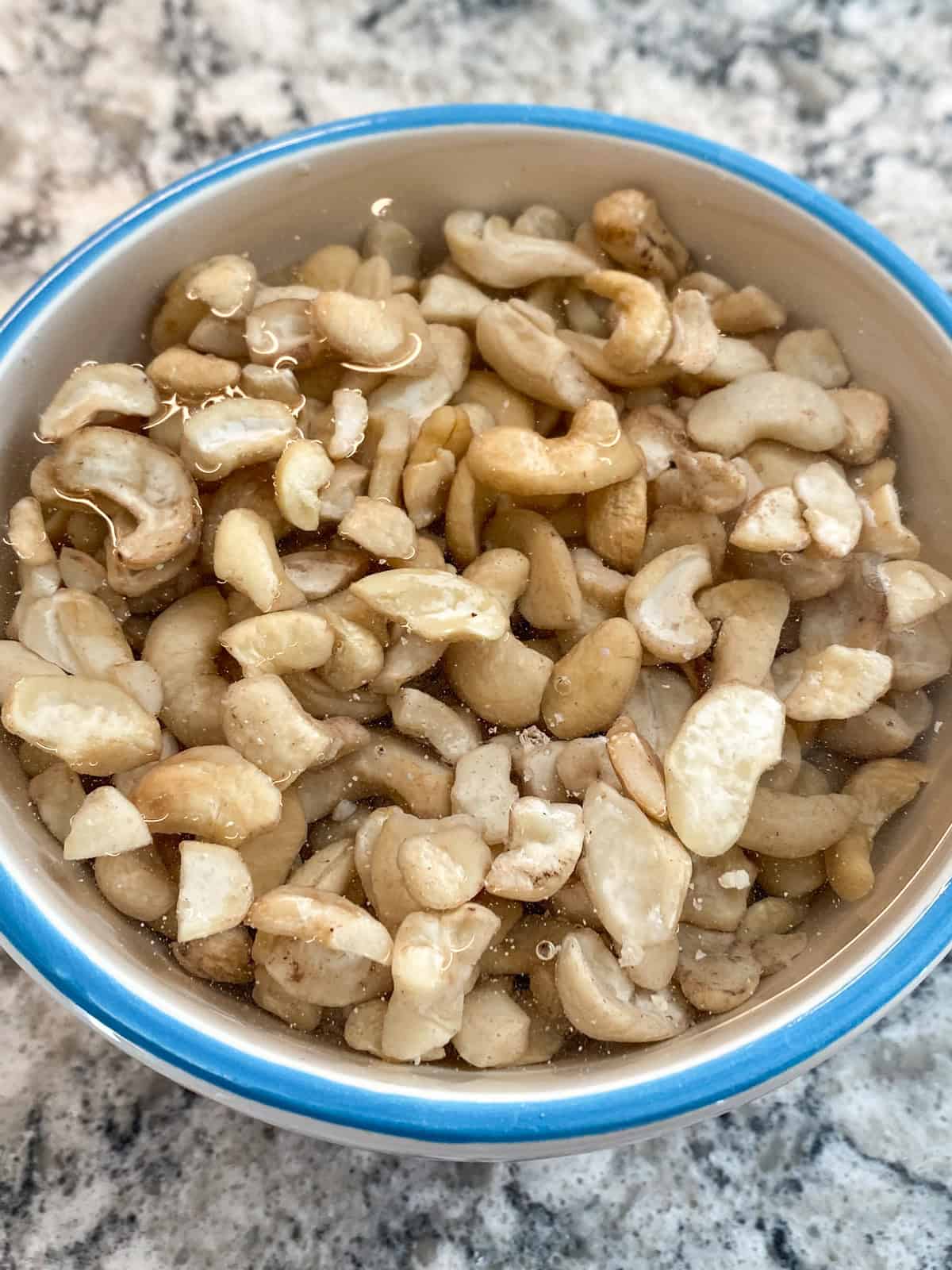 Bowl of cashews soaking in water.