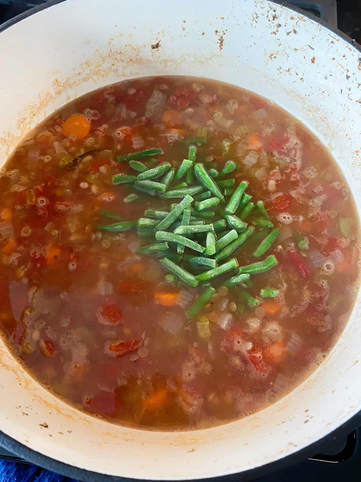 Frozen green beans added to the boiling soup/