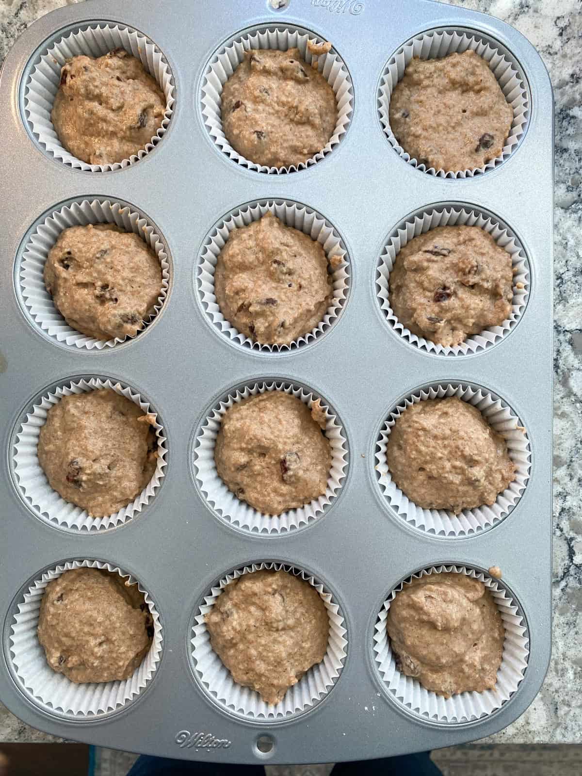 Muffin batter in prepared muffin pan.