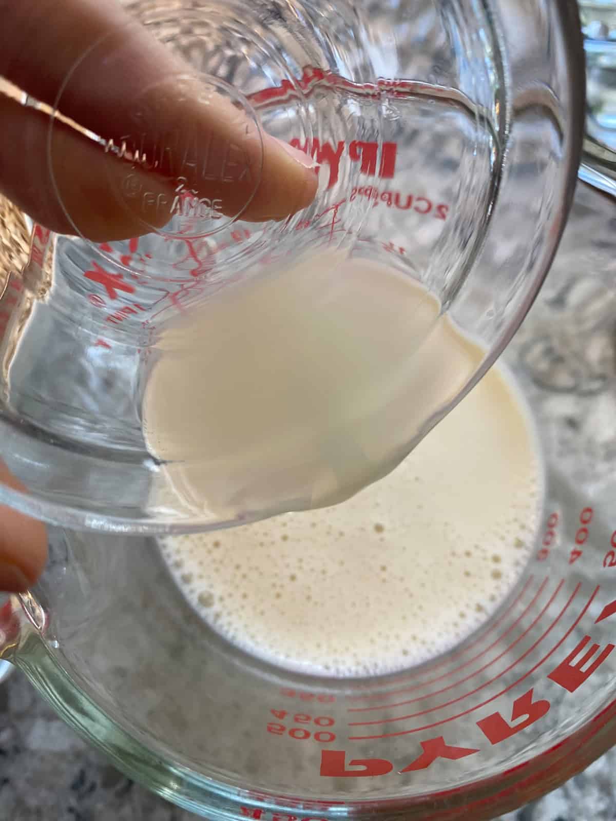 Lemon juice being poured into milk, to make homemade buttermilk.