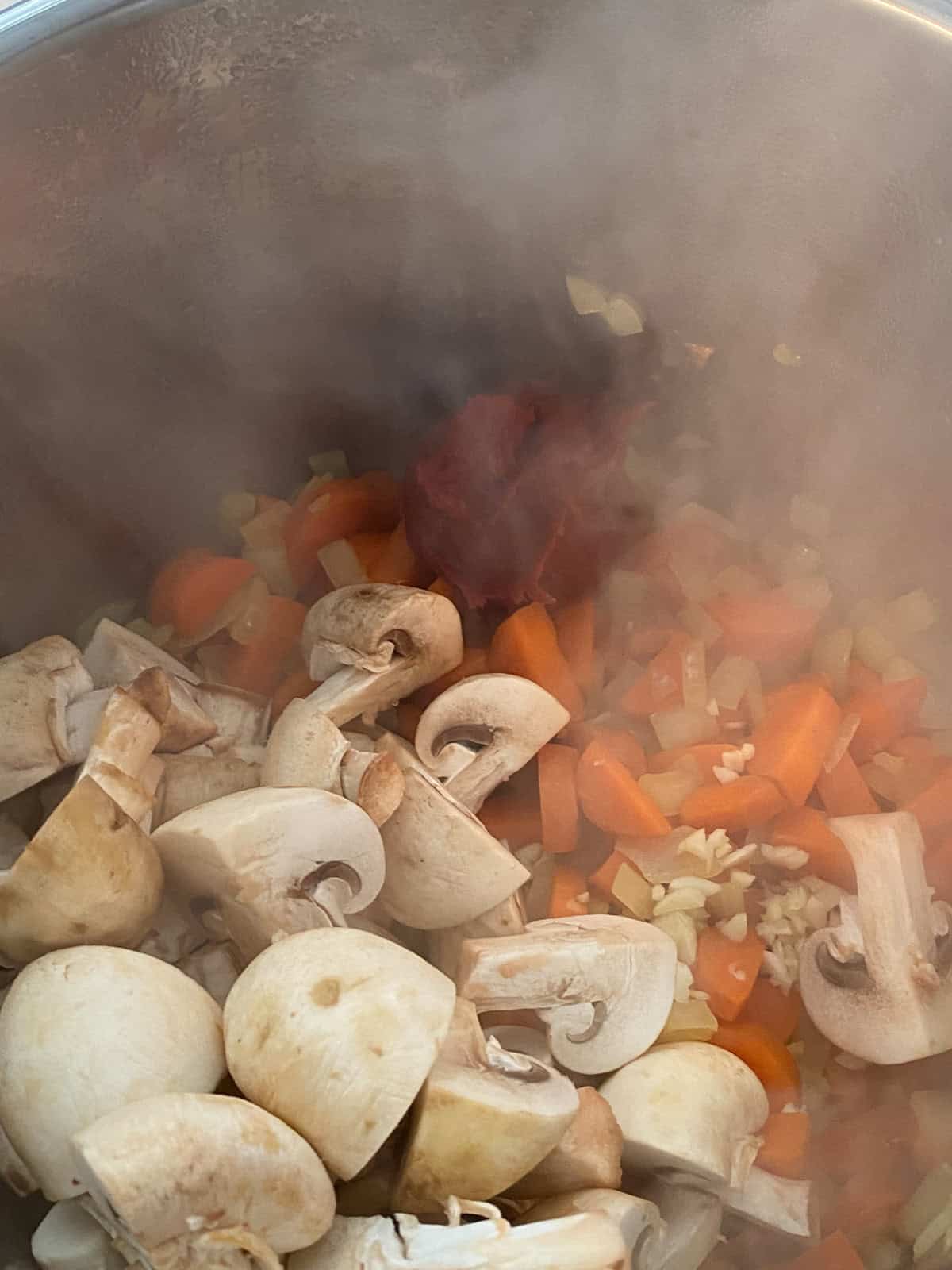 Mushrooms, garlic, and tomato paste added to instant pot.
