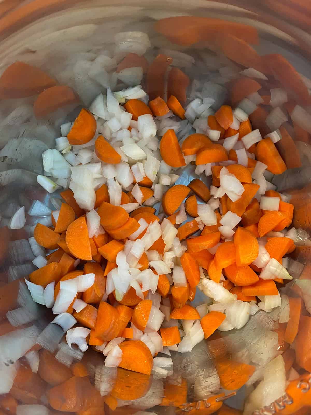 Chopped onions and carrots sauteing in the instant pot.