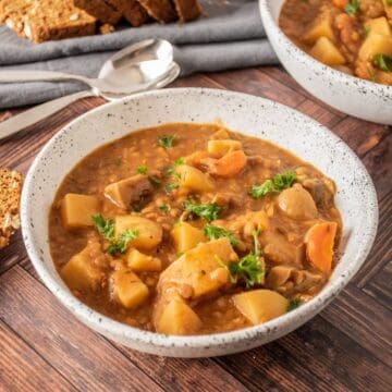 Bowl of lentil and mushroom stew, garnished with parsley.