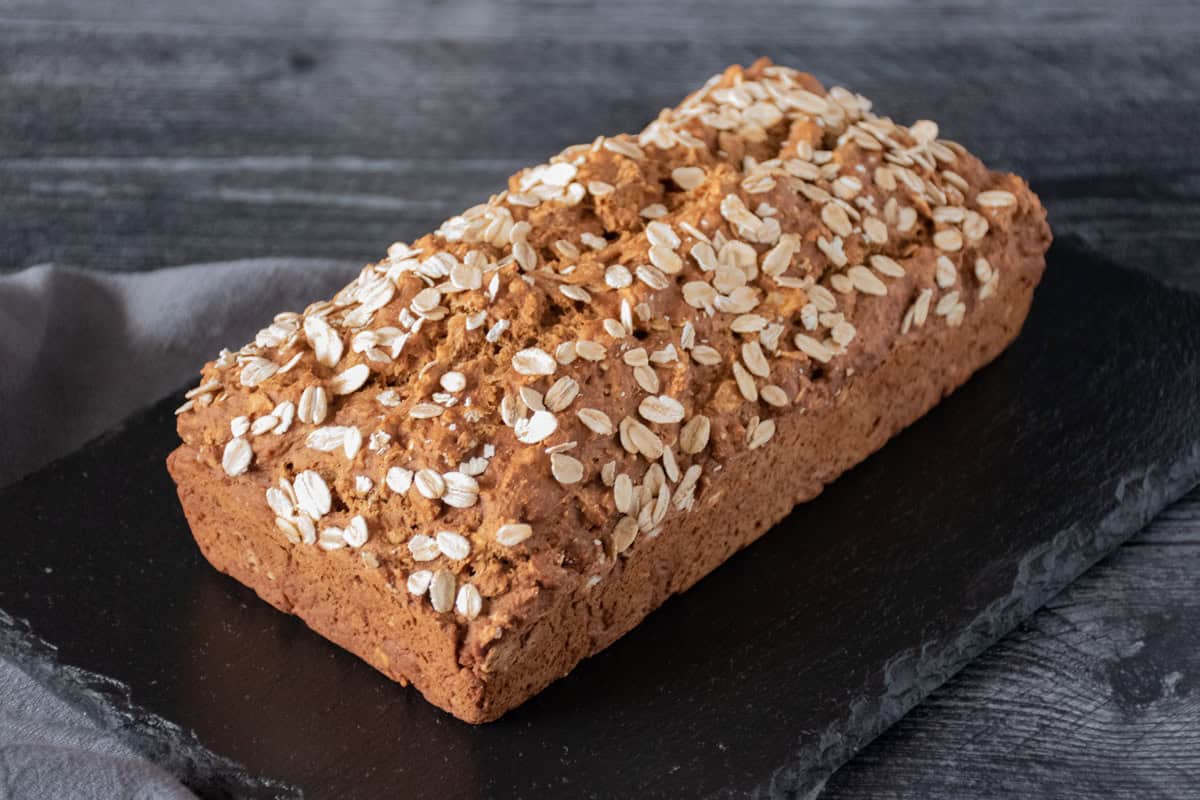 Loaf of bread with oats sprinkled over the top.