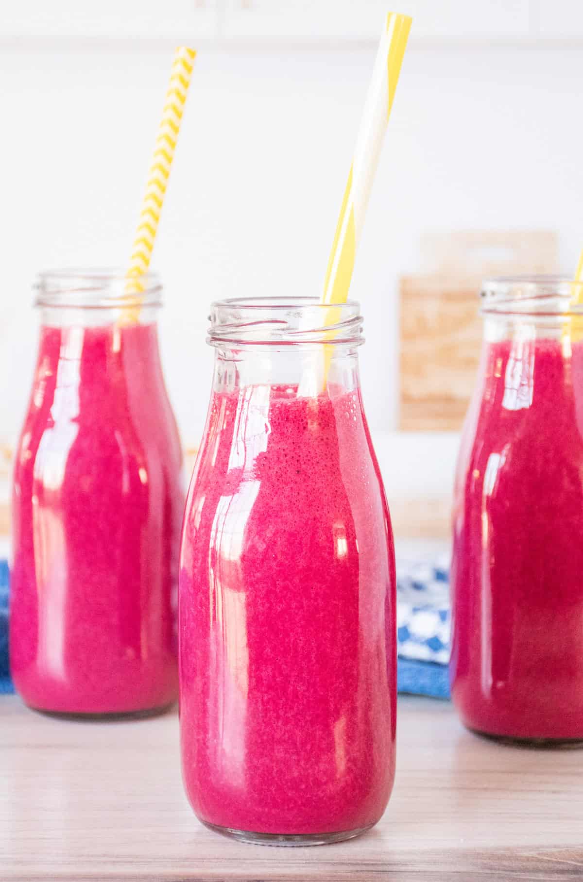Three small jars of smoothie, with straws.