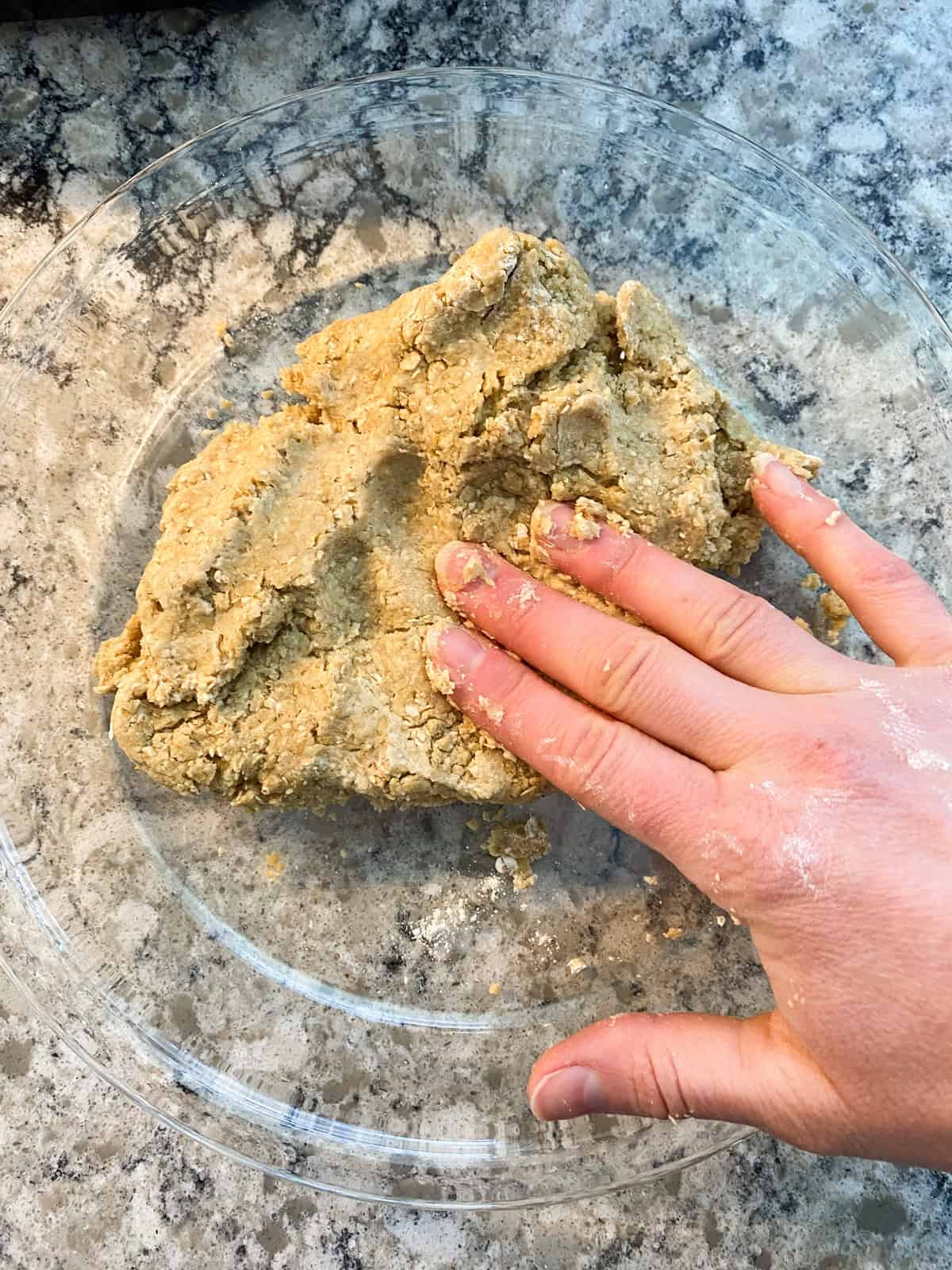 Dough being pressed into the pie plate.