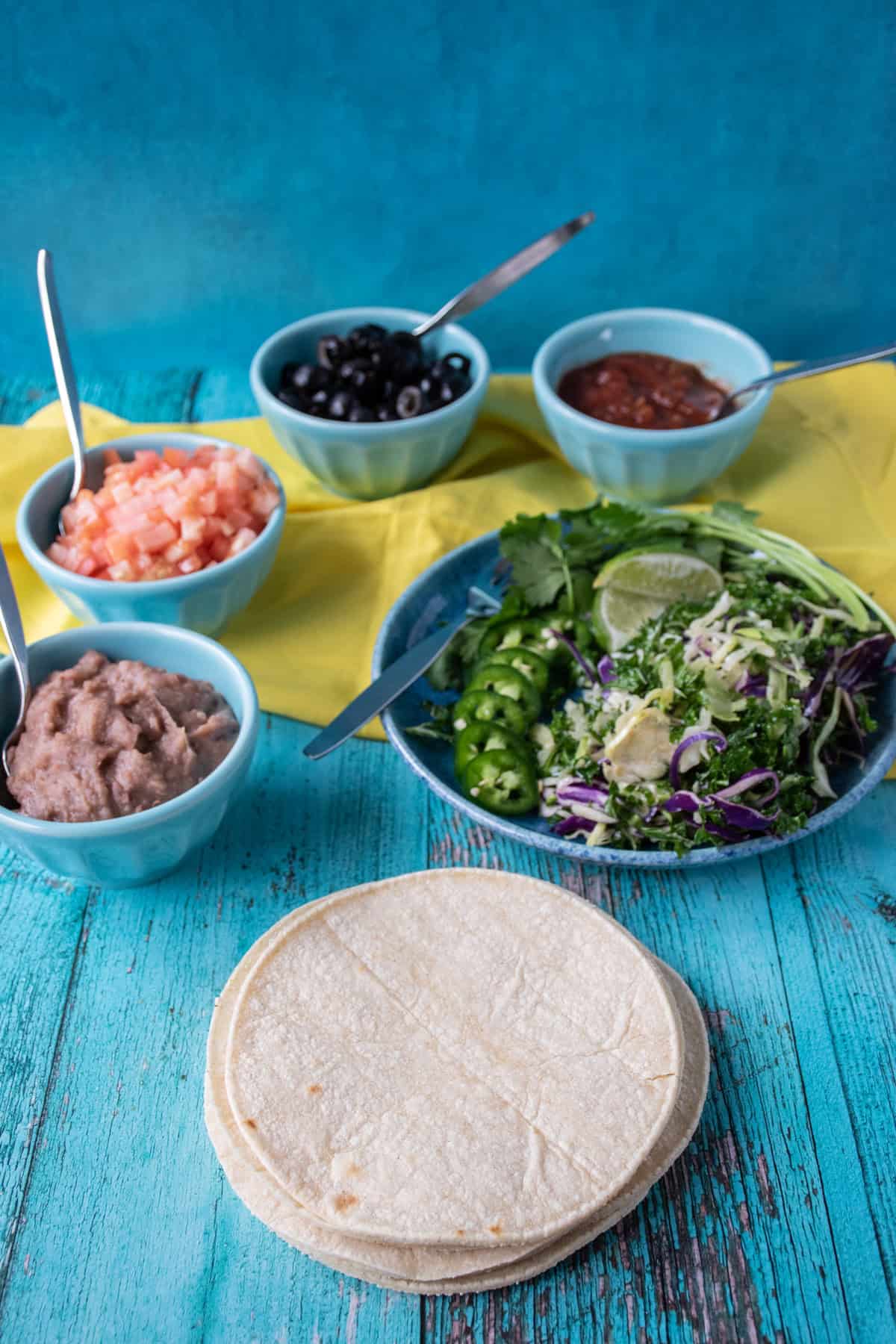 Spread for make your own tacos on a table, with each ingredient in an individual bowl or plate.