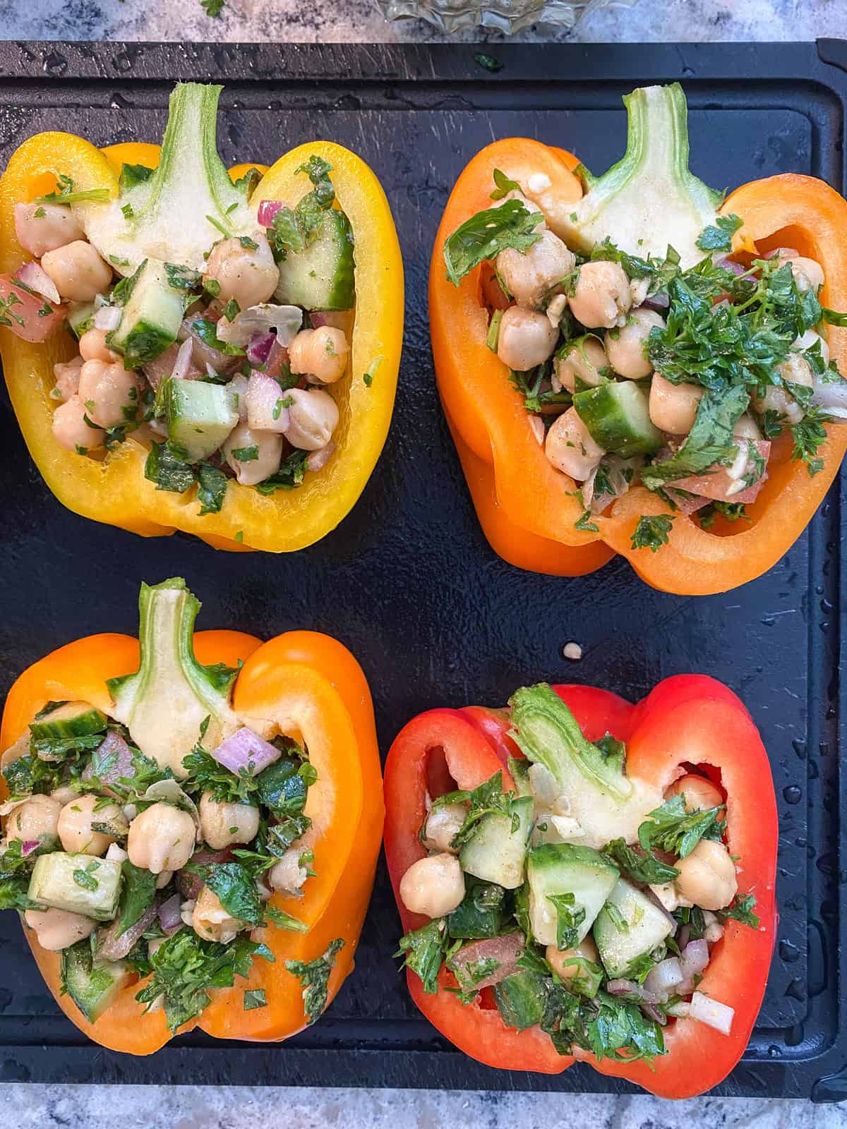 Bell peppers, halved, with chickpea salad filling each half.