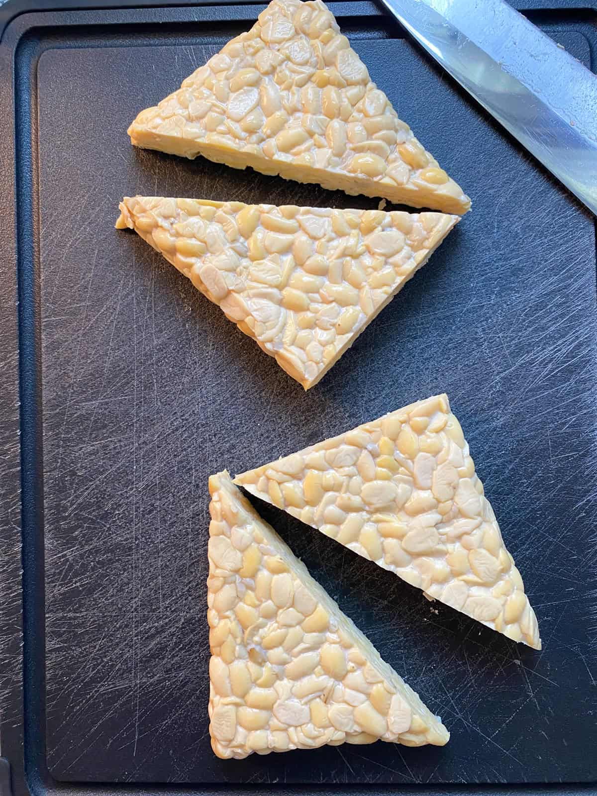 Tempeh halved, and sliced into triangles.