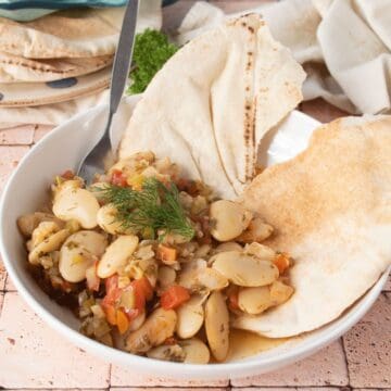 Greek lima beans in a bowl, with a pita.