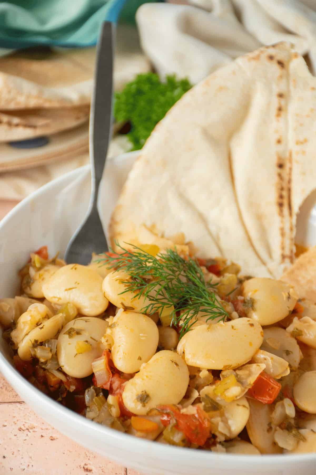 Greek lima beans in a bowl, with a pita.
