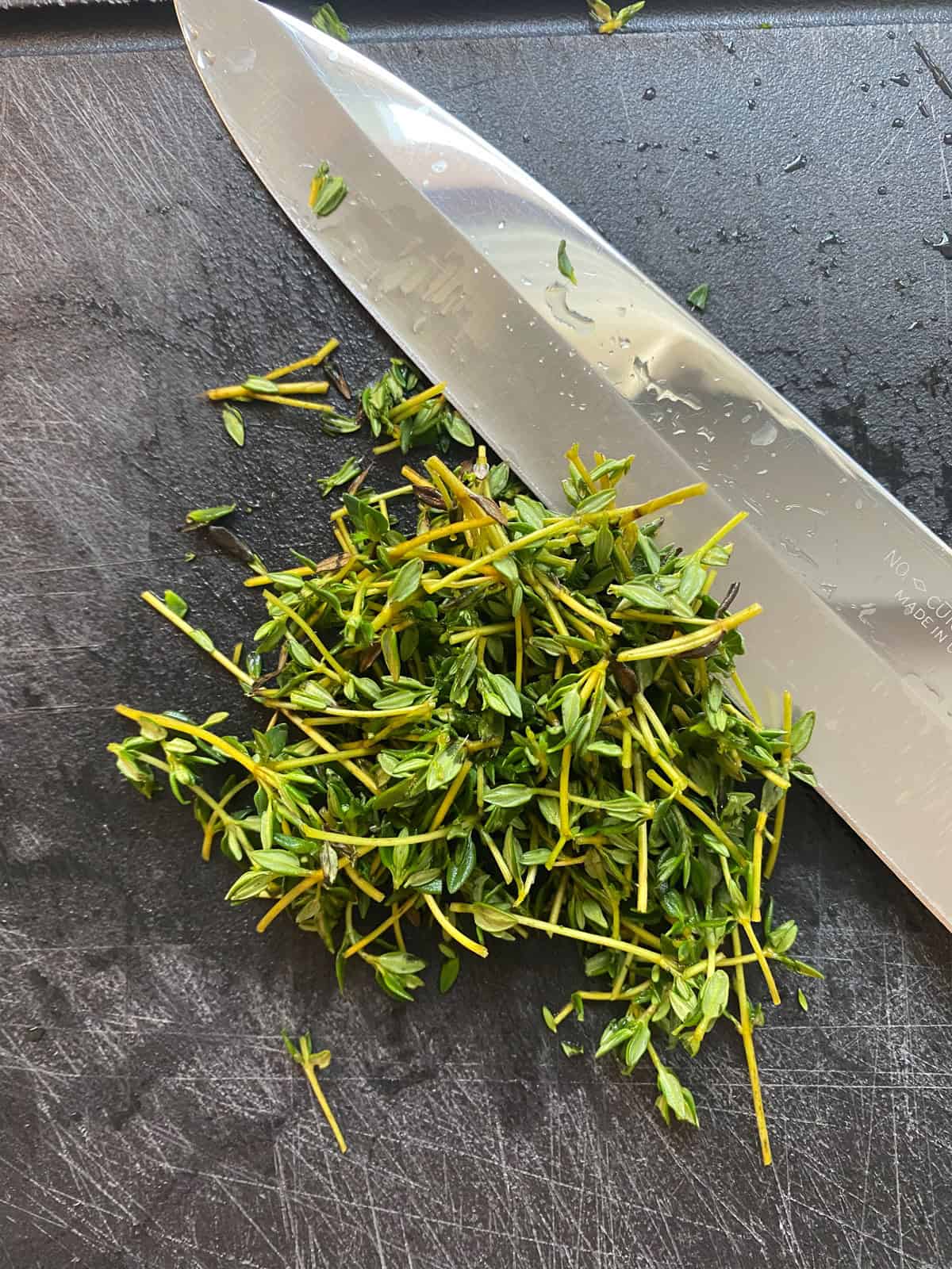 Thyme sprigs, chopped on a cutting board.