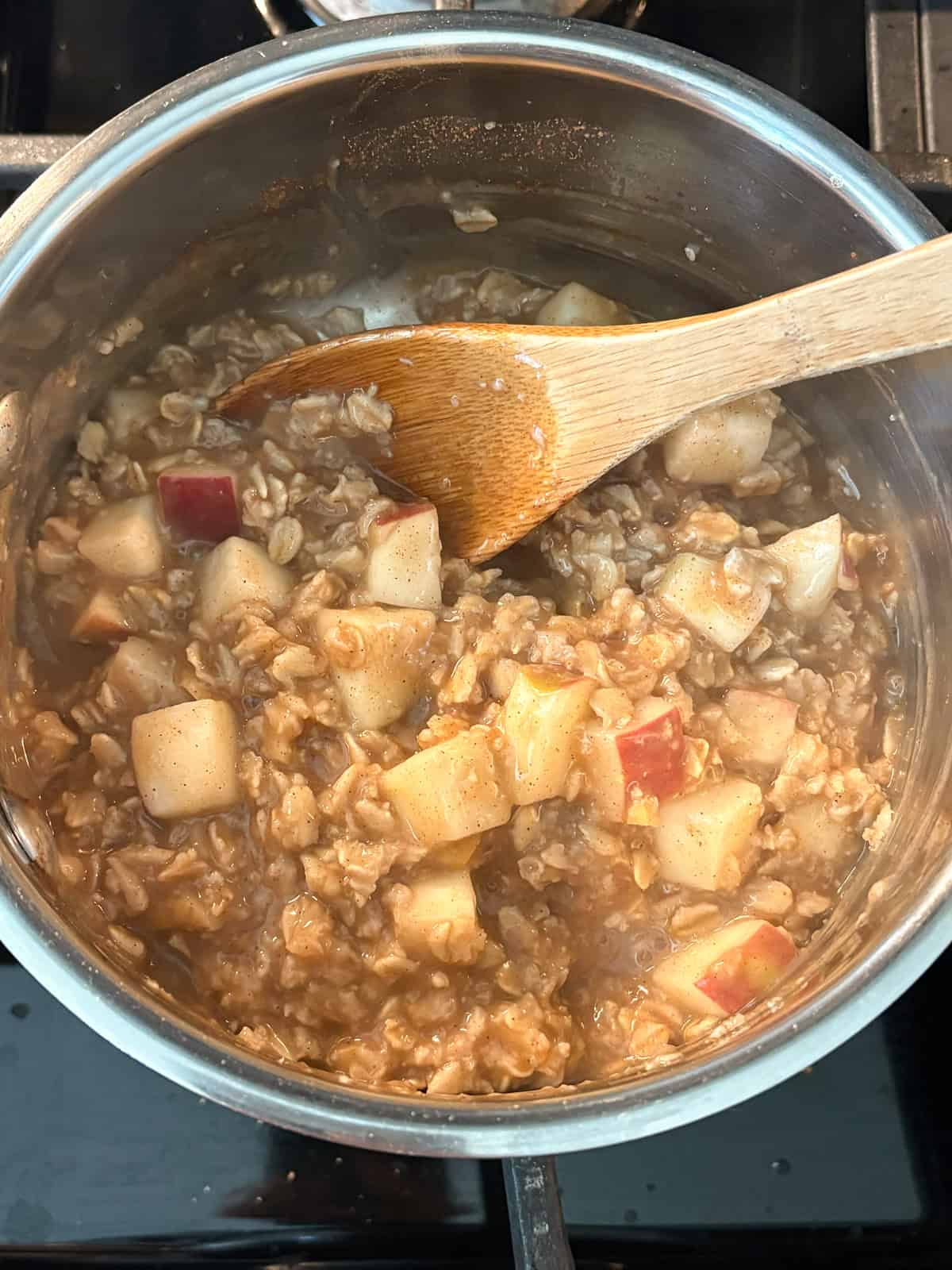 Oatmeal in a small pot, cooked and thickened.