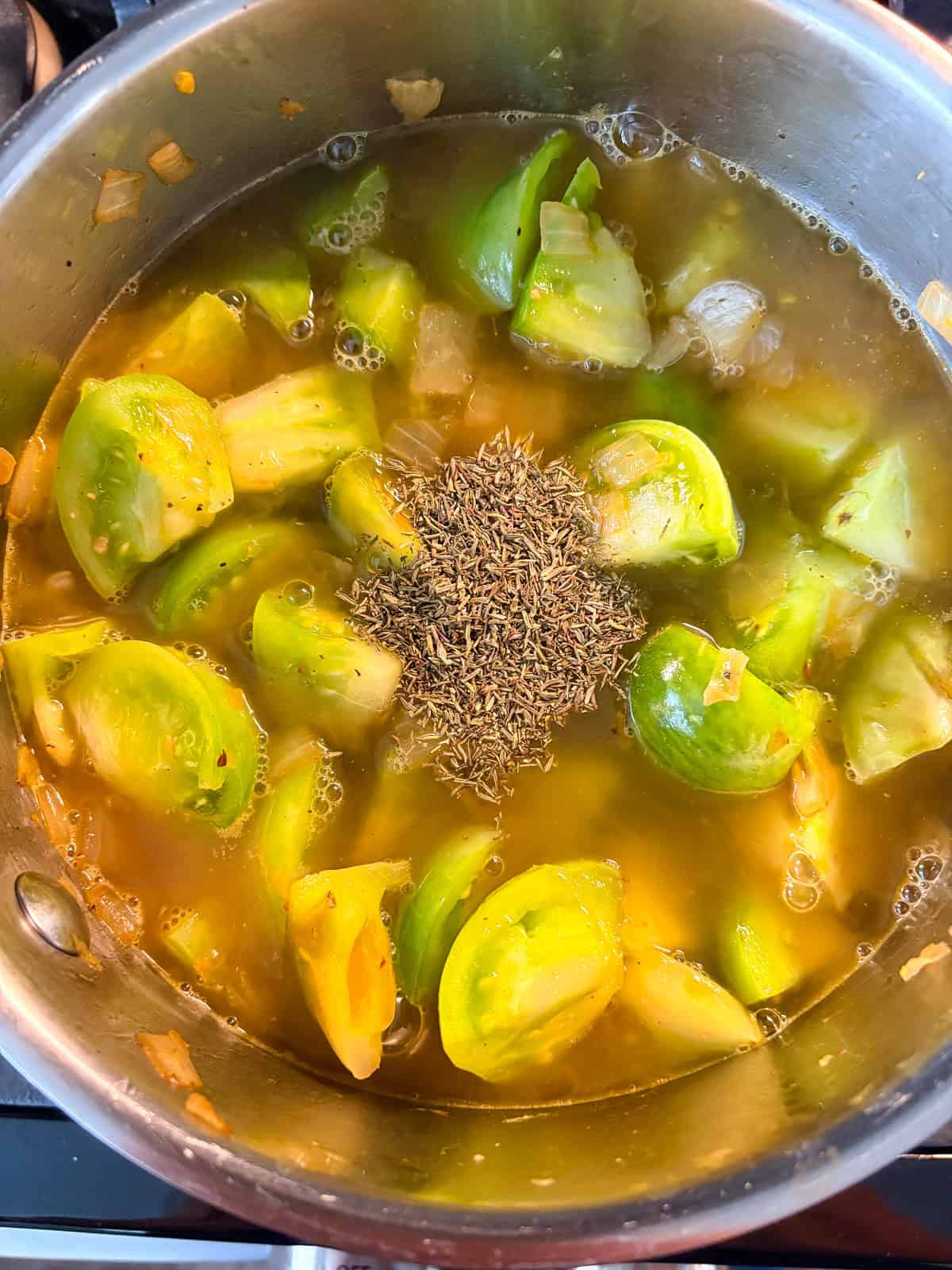 Vegetable stock and dried thyme added to pot.