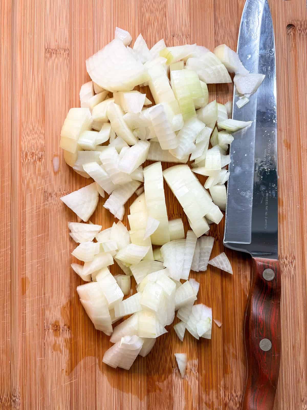 Onions, chopped, on a cutting board.