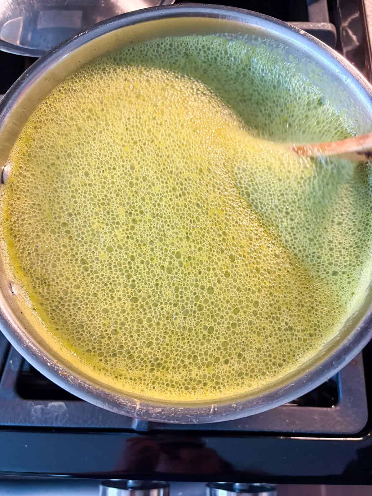 Bubbles forming in the soup after baking soda is added.