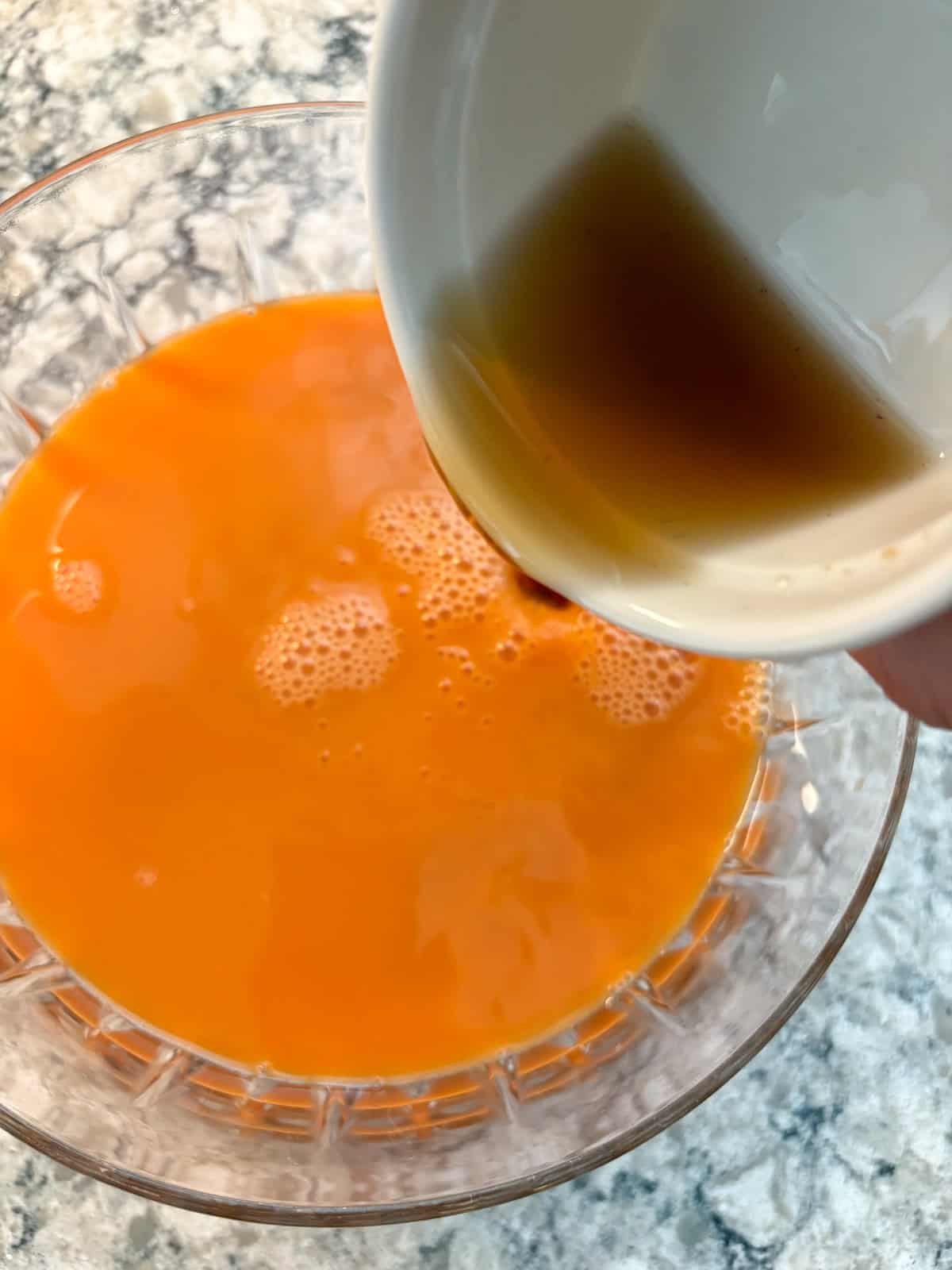 Spiced maple syrup being poured into the punch bowl.