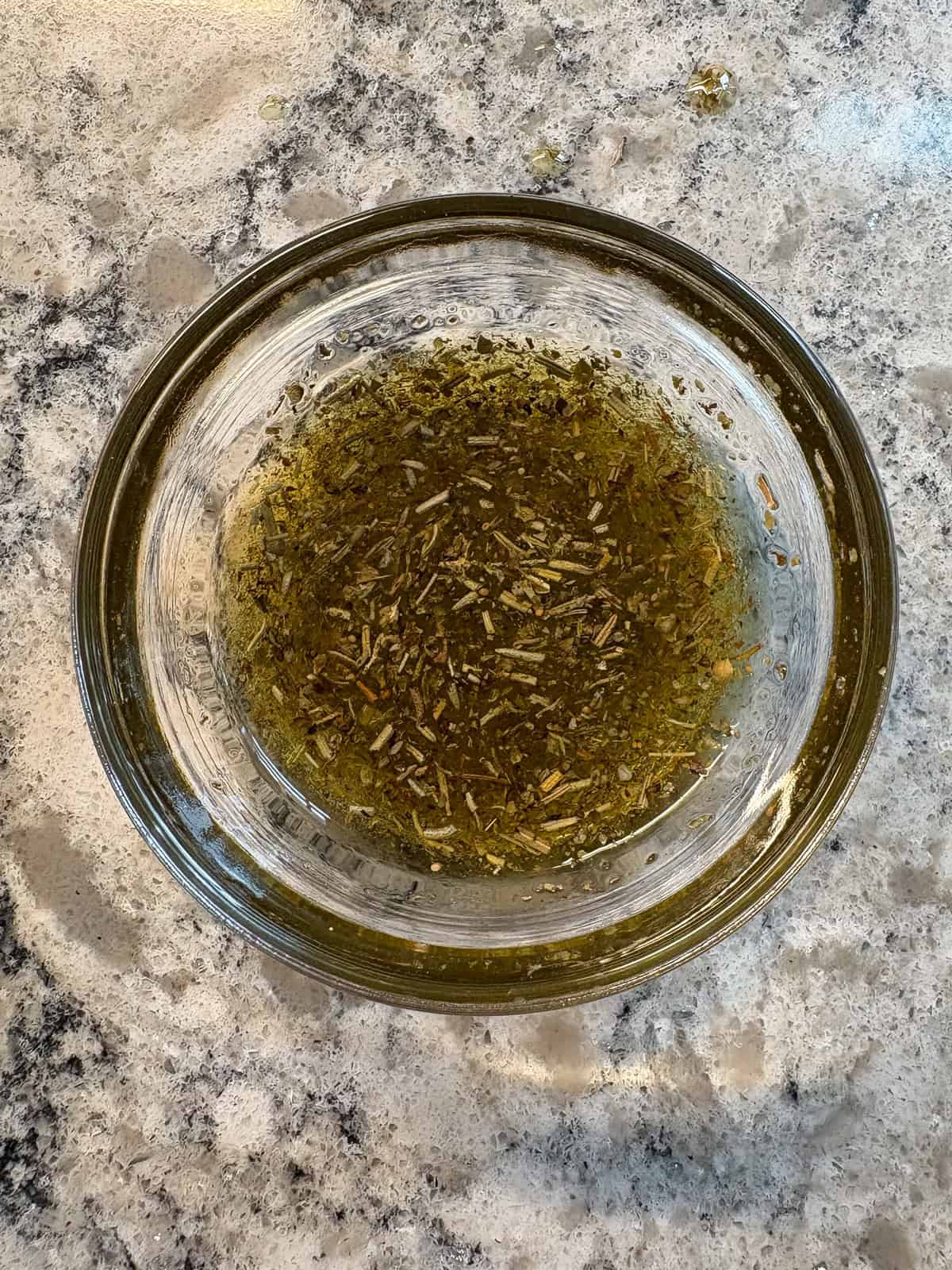Oil, vinegar, and Italian seasoning mixed together in a small bowl.