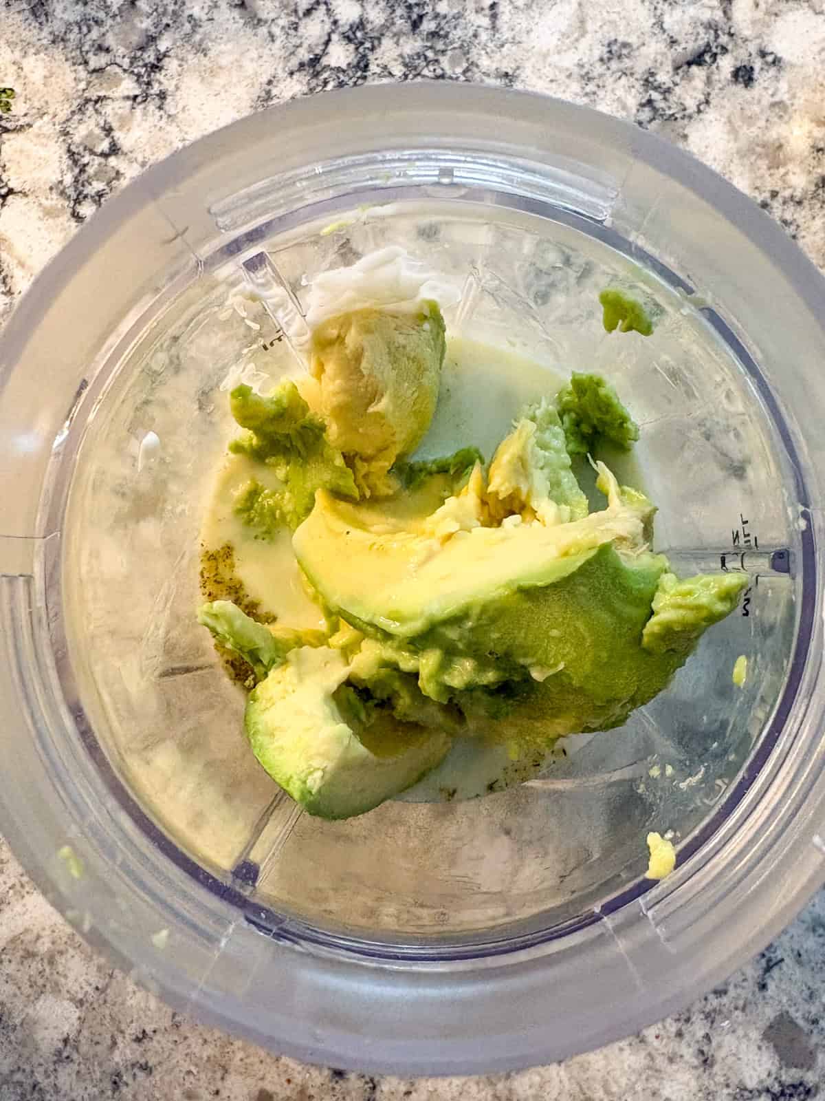 Blender with avocado added in to the rest of the ingredients.