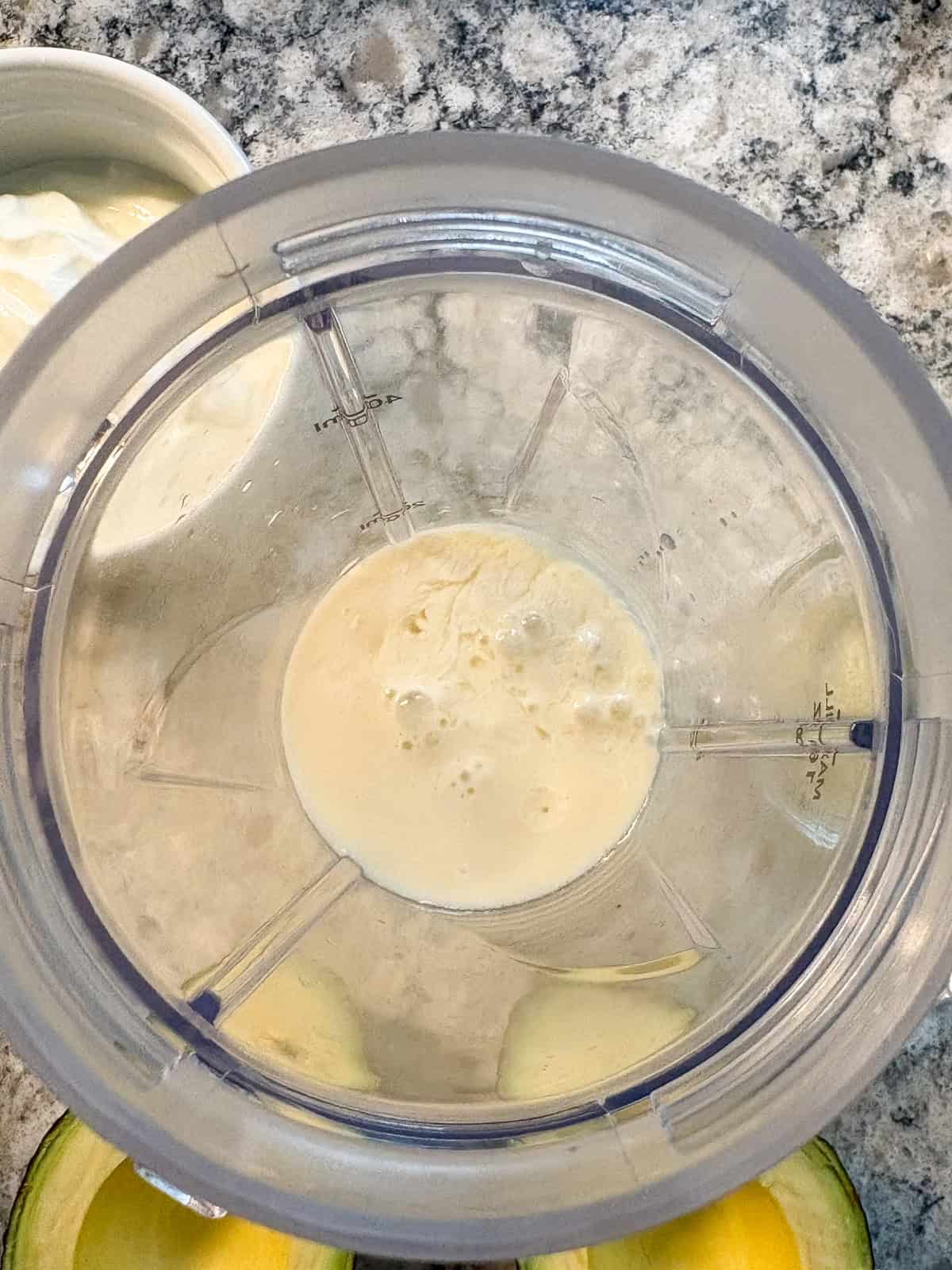 Small blender with non dairy milk and lime juice added to it.