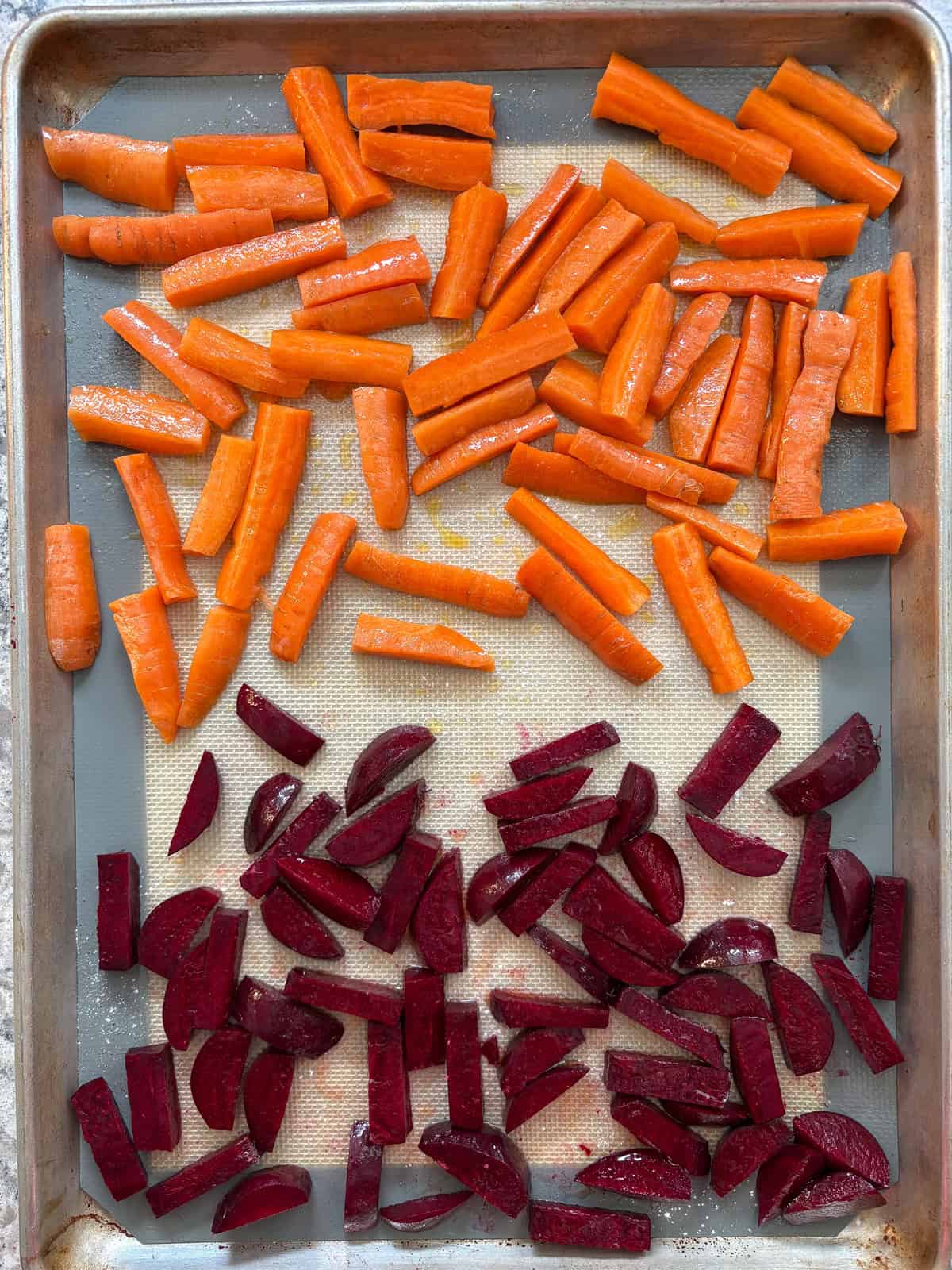 Cut, raw, beets and carrots, tossed with oil.