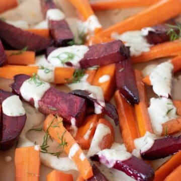 Roasted beets and carrots, cut into large matchsticks, drizzled with a white sauce and sprinkled with chopped dill.