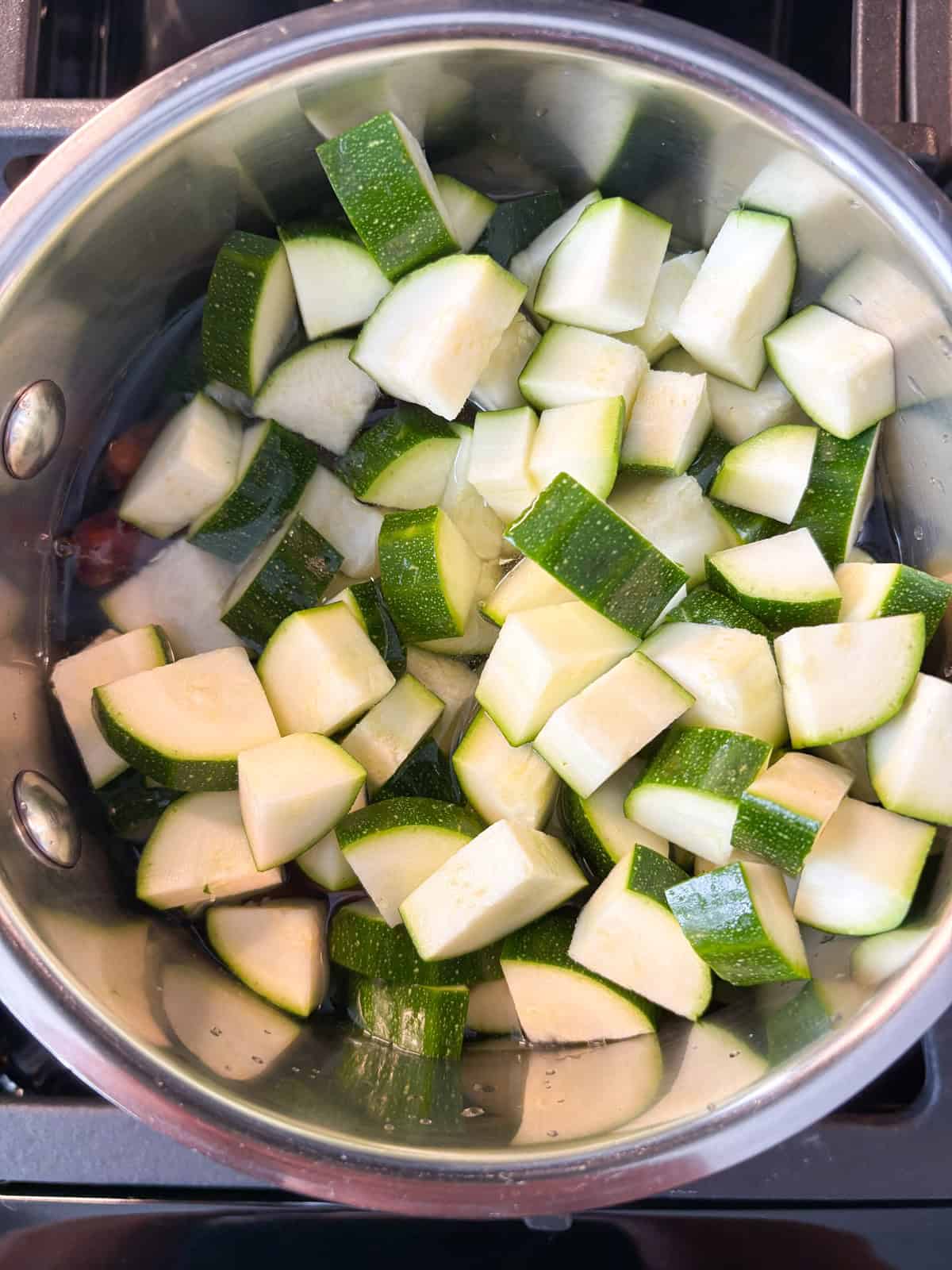 Zucchini, dates, and water combined in a small pot.