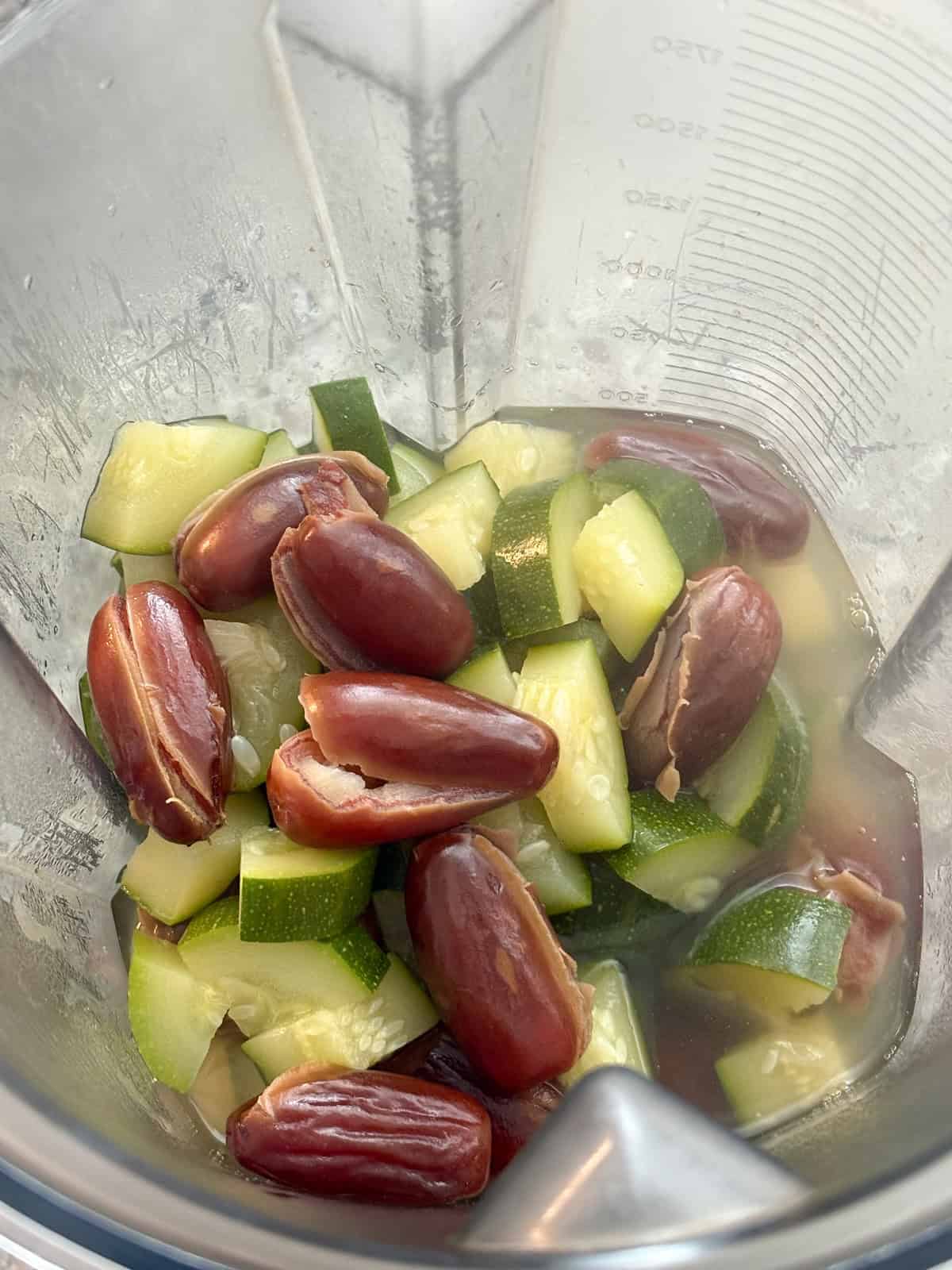 Zucchini, dates and water poured into a blender.