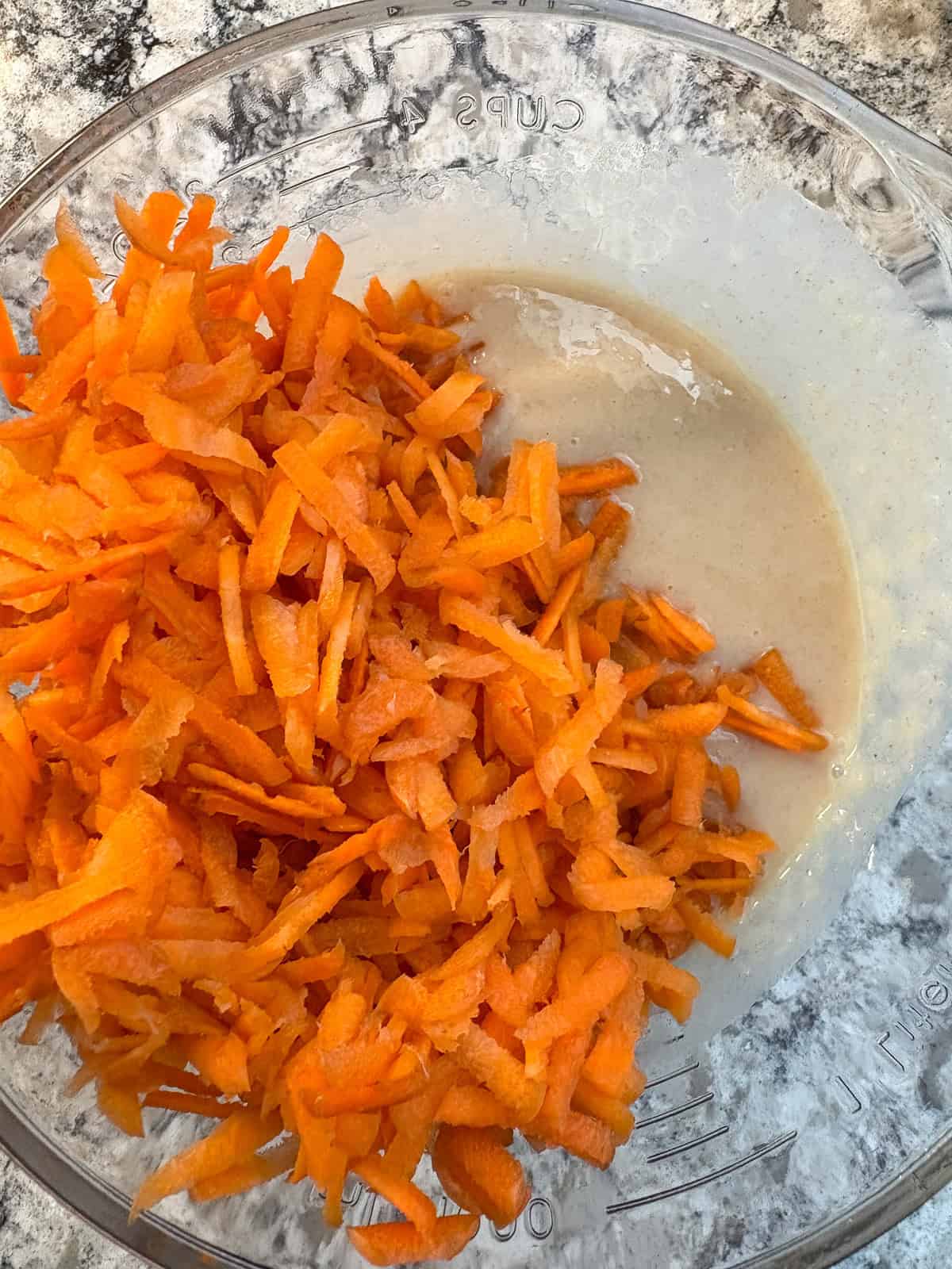 Shredded carrots added to wet ingredient mixture.