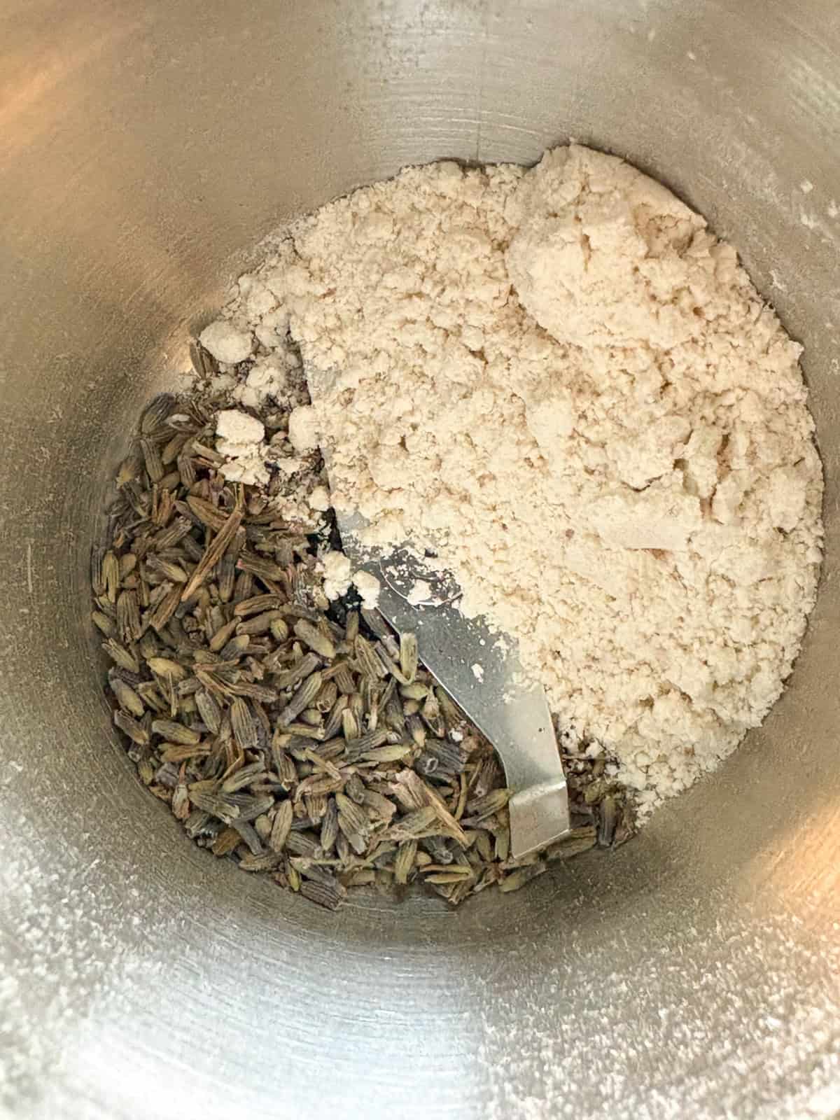 Lavender buds and a spoonful of flour in a spice grinder.