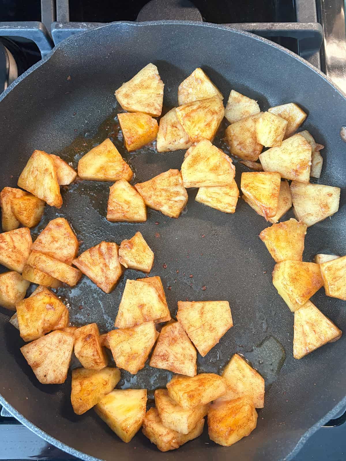 Pineapple sautéing in a pan.