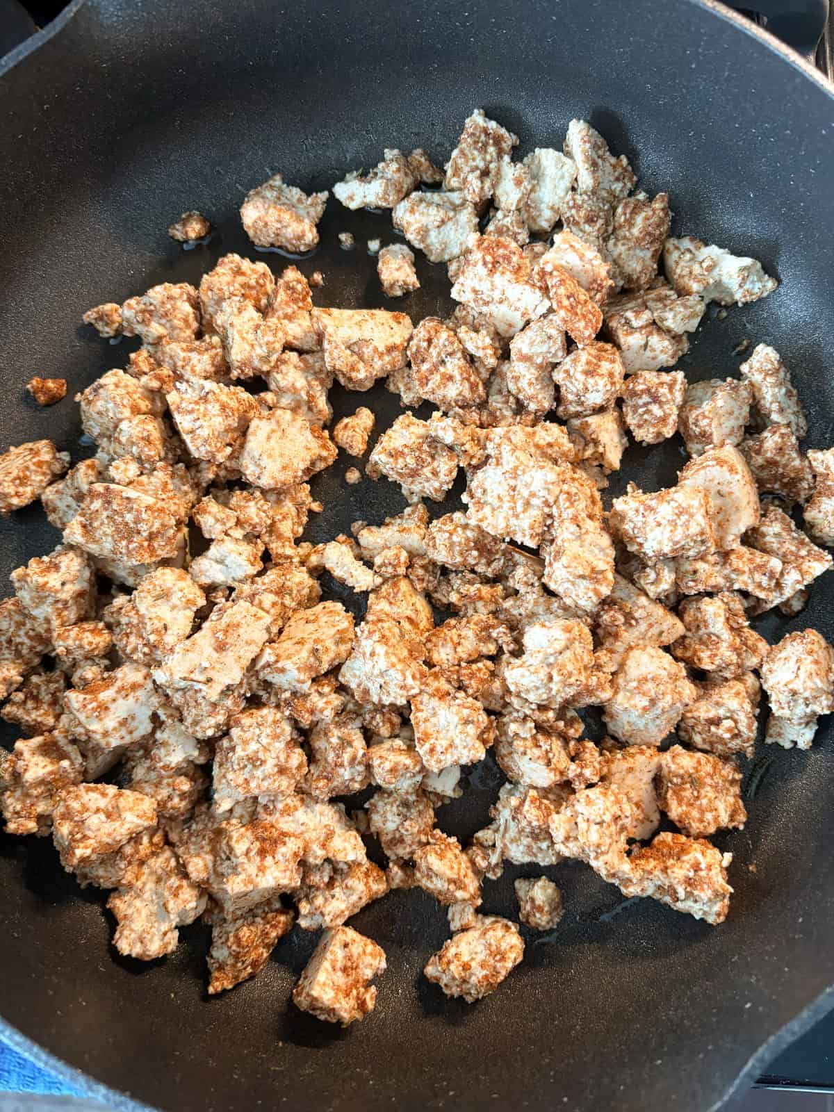 Tofu sautéing in a pan.
