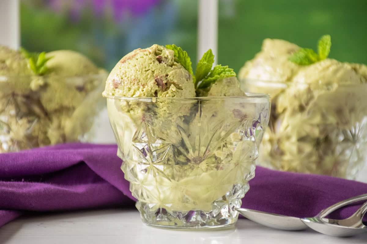 3 glass cups of mint chip ice cream, garnished with fresh mint leaves.
