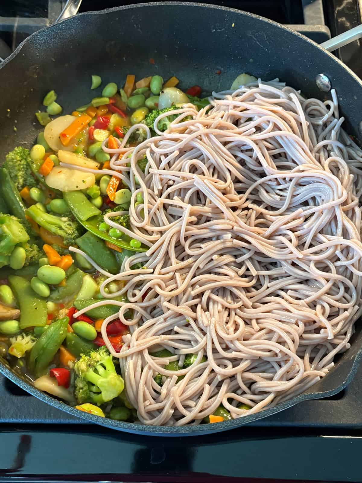 Noodles added to the skilled with the veggies and sauce.