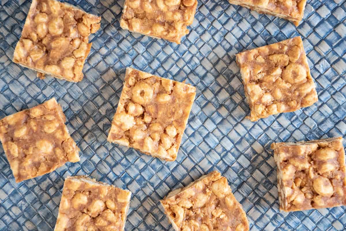 Overhead image of cereal bar squares on a blue straw mat.