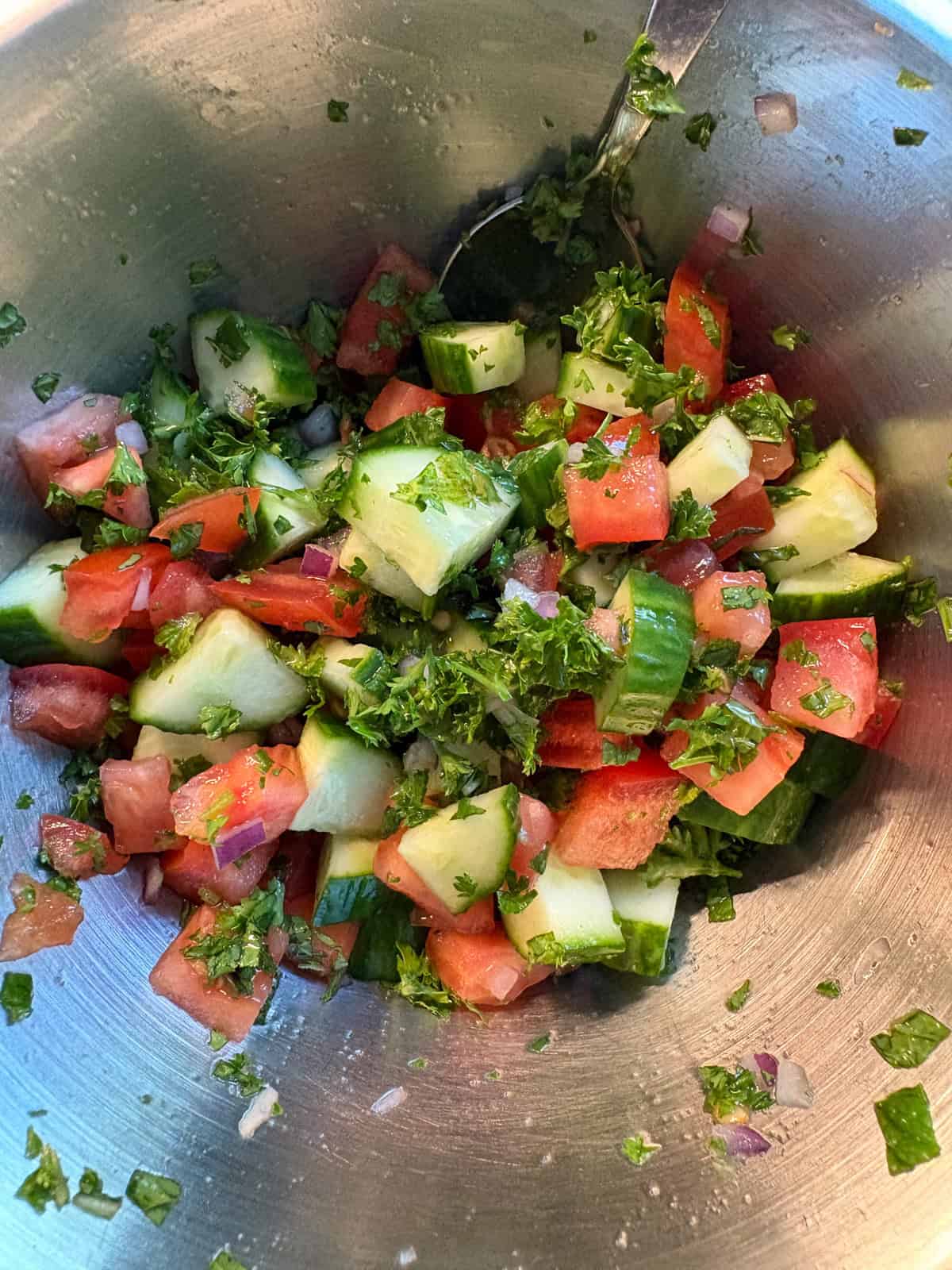 Tossed cucumber salad in a mixing bowl.