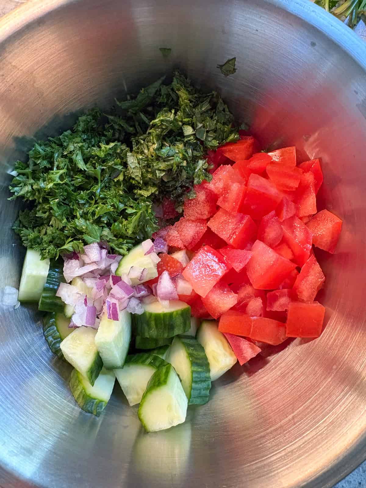 Ingredients for the cucumber salad, chopped, in a bowl.